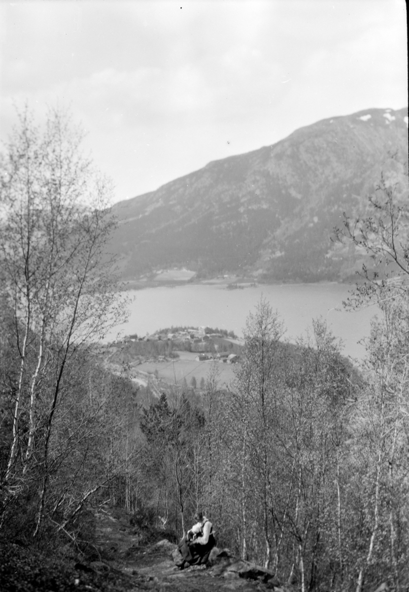 Vågå, Vågåvatnet, utsikt fra oppi sørsiden og mot nordvest. Kvinne i bunad sitter ved stien