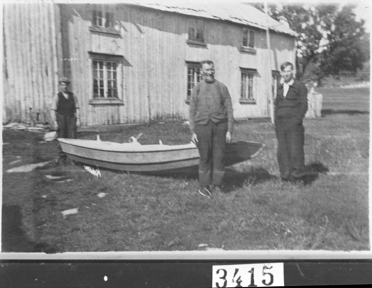 Tre menn står i hagen med en robåt, Stjørna.