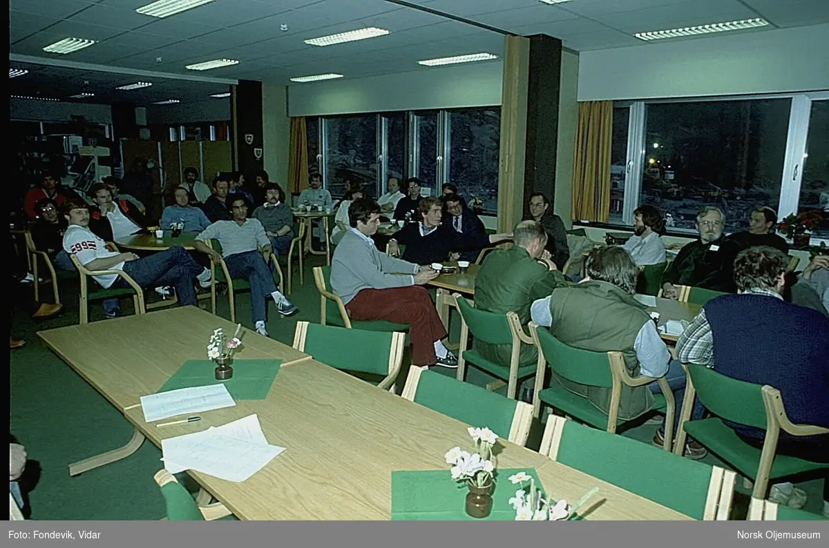 Bildene er antakelig tatt i et fellesmøte på NUI.  Flere personer er samlet i det som kan være en kantine.