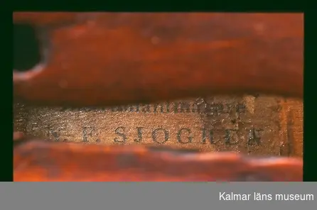 KLM 39521 Fiol, av trä. Fiol med tre stämskruvar. Stränghållare, stall och strängar saknas. Försedd med invändig tillverkaretikett, text: Förfärdigad af Instrumentmakare N. F. Sjögren i Calmar 1829.