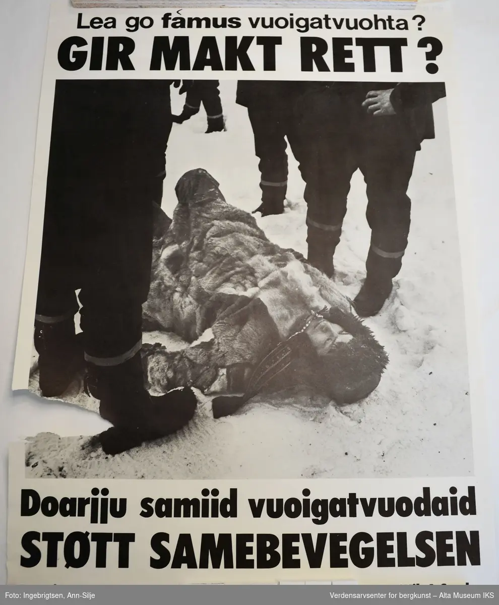 Samisk mann kledd i pesk ligger på bakken omgitt av politi.