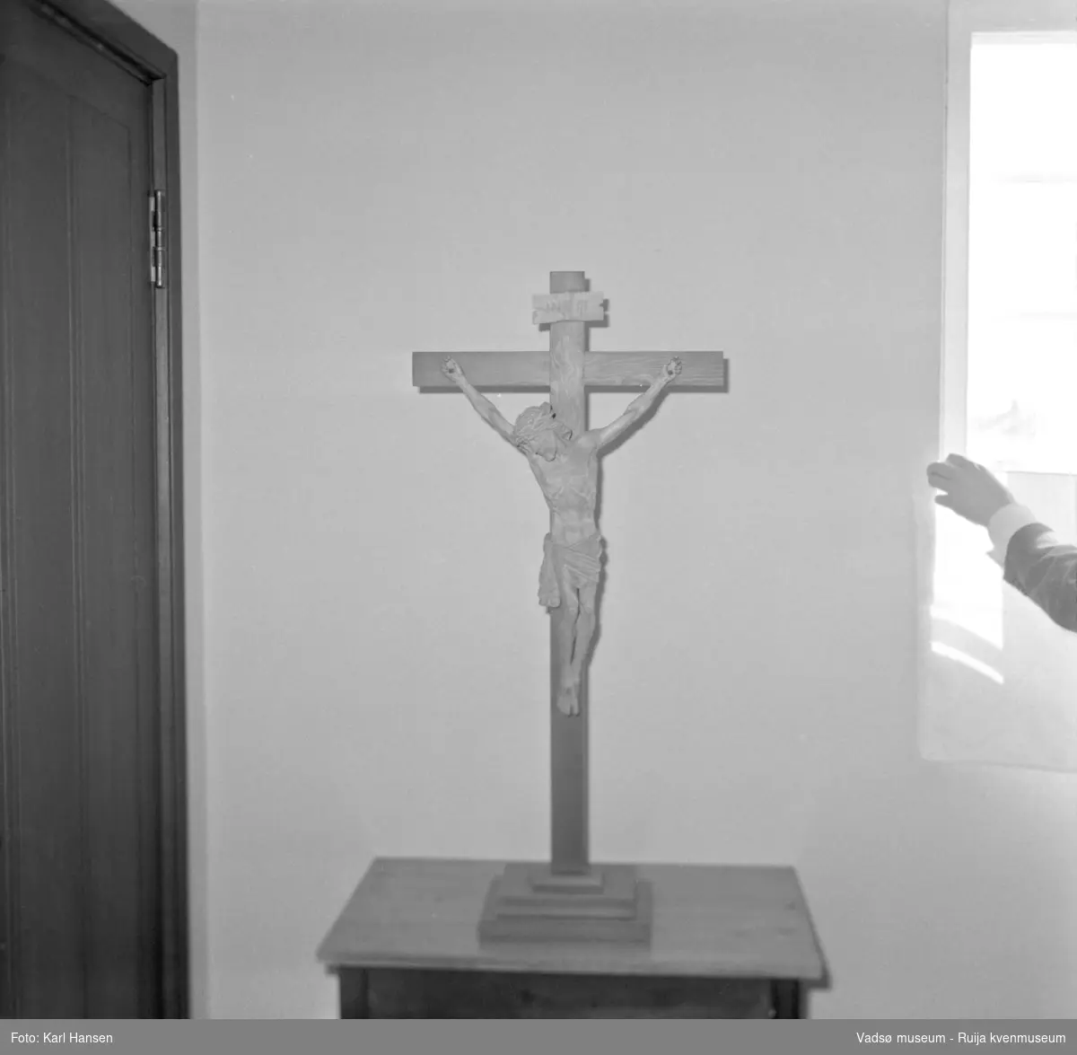 Vadsø kirke 7.5.1969. Utsmykking: kors med korsfestet Kristusfigur.  Vadsø kirke ble vigslet i 1958, tegnet av Magnus Poulsson, utsmykket av Greta Thiis.