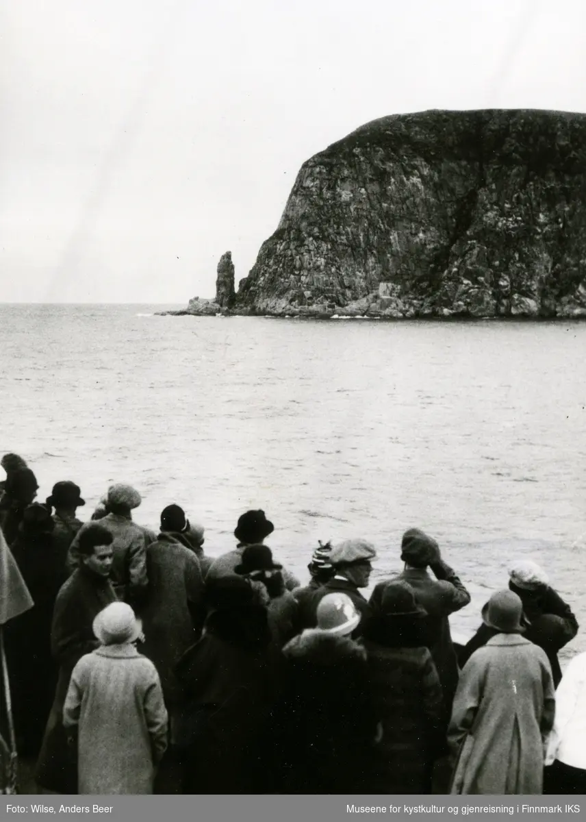 Turister på vei til Nordkapp med D/S "Stavangerfjord" se på fuglebjerget Hjelmsøystauren. Sommeren 1925. (Originalnegativet eies av Norsk Folkemuseum, W 26910)