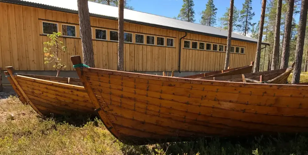 Gamle som står ute på Blokkodden med magasinhallen i bakgrunnen.