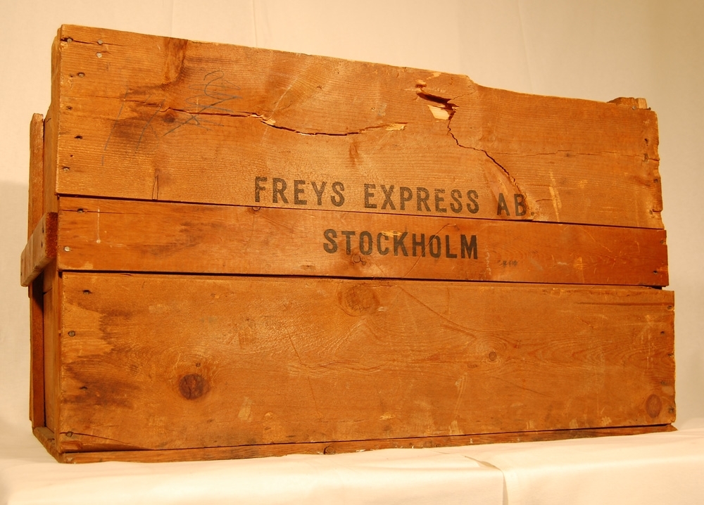 Trälåda eller lår för transport, tillverkad av sågade brädor spikade med trådspik och märkt "Freys Express AB Stockholm" på sidan.