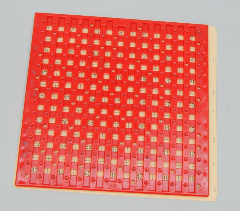 Rättningsmallar, 2 st, en gul och en röd, i fodral av grå plast med transparent lucka med hål. Rättningsmallarna består av ett rutnät som sättes över tillhörande svarskort vid rättning av dessa. Där rutorna korsas finns antingen hål eller gropar. Sidorna på mallarnas ena sida är märkta 1-4 och på motstående sida 5-8. På baksidan av fodralet sitter en gul rektangulär klisteretikett med den tryckta texten "STATENS JÄRNVÄGAR SJ-Skolan ÄNGELHOLM" samt med röd handskrift "Skolfa 11".