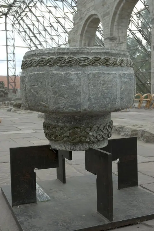 Baptism fountain in soapstone with a braid border around the edge.