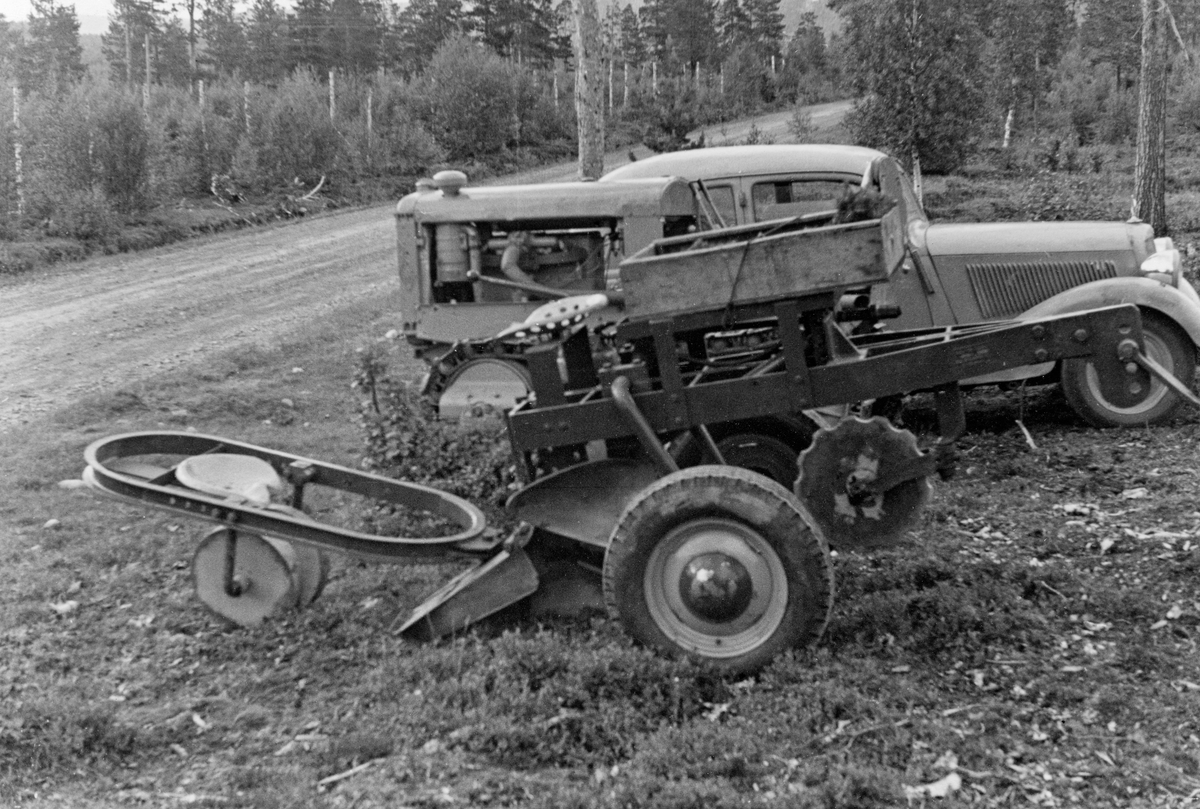 Treplantemaskin av det amerikanske merket «Badger», fotografert i forbindelse med forsøksdrift på Forsetmoen i Bardu i Troms i 1950.  Maskinen var bygd på ei kraftig stålramme med gummihjul.  Under dragstengene var det montert et skjær, ei rund, roterende stålplate, som skulle lage et snitt i marksjiktet.  Deretter ble jorda løsnet og blandet av to bakenforståede veltefjøler.  En plantør på et stålsete bak på maskinen førte planter ned i en «plantesko» av stål, før to stålplater feide jord over røttene.  Til slutt ble jorda pakket rundt planterøttene av to svakt skråstilte stålhjul (til venstre på dette bildet).  Plantereservoaret ble oppbevart i trekassa bak plantørsetet.  Pløye- og plantedybden kunne reguleres ved hjelp av en hydraulisk spak.  Maskinen ble importert til Norge sammen med en «motorplog» som kunne monteres på den samme ramma.  Da forsøkene startet ble plantemaskinen og plogen forsøkt trukket av en Ferguson-traktor, men den dro for ujevnt, og ble erstattet av en tung beltetraktor, som ses bak plantemaskinen på dette bildet.  Bak traktoren igjen ser vi en bil, sannsynligvis en Mercedes-Benz 170 fra 1930-tallet.  Bildet er tatt ved vegkanten på Forsetmoen.  Mer informasjon om disse første forsøkene med maskinell skogplanting i Norge finnes under fanen «Opplysninger».

Fotografiet er hentet fra et kartotek som ble samlet av Waldemar Opsahl, som var statskonsulent for skogkultursektoren fra 1936 til sin død i 1954.  Arkivet ble overlatt til Norsk Skogbruksmuseum i Tore Fossums bestyrertid.  Opsahl har antakelig tatt de fleste av bildene i arkivet.  Materialet består av pappkort med opplimte kopier av svart-hvitt-fotografier.  Kortet med dette fotografiet på er merket "Al.2" og "(1427)".  Under bildet er det påklistret en liten papirstrimmel med påskriften:

«Badger plantemaskin.  Forsetmoen, Bardu. fot. W.O.1950»