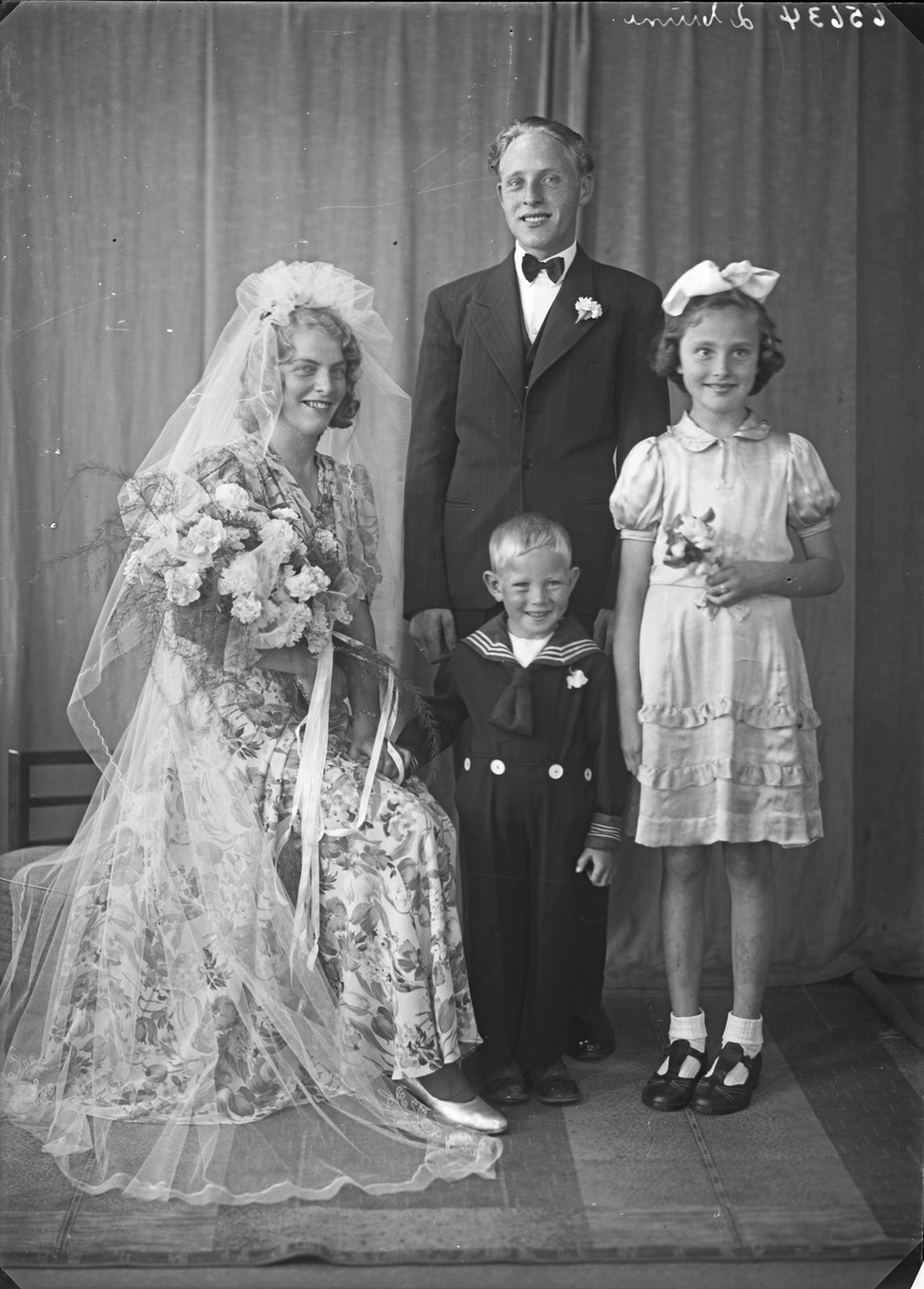 Brudebilde. Ung kvinne i blomstret brudekjole, ung mann, pike og ung gutt i matrosdress. Brudegruppe. Bestilt av Hr. Arthur Nyland. Sørhaug