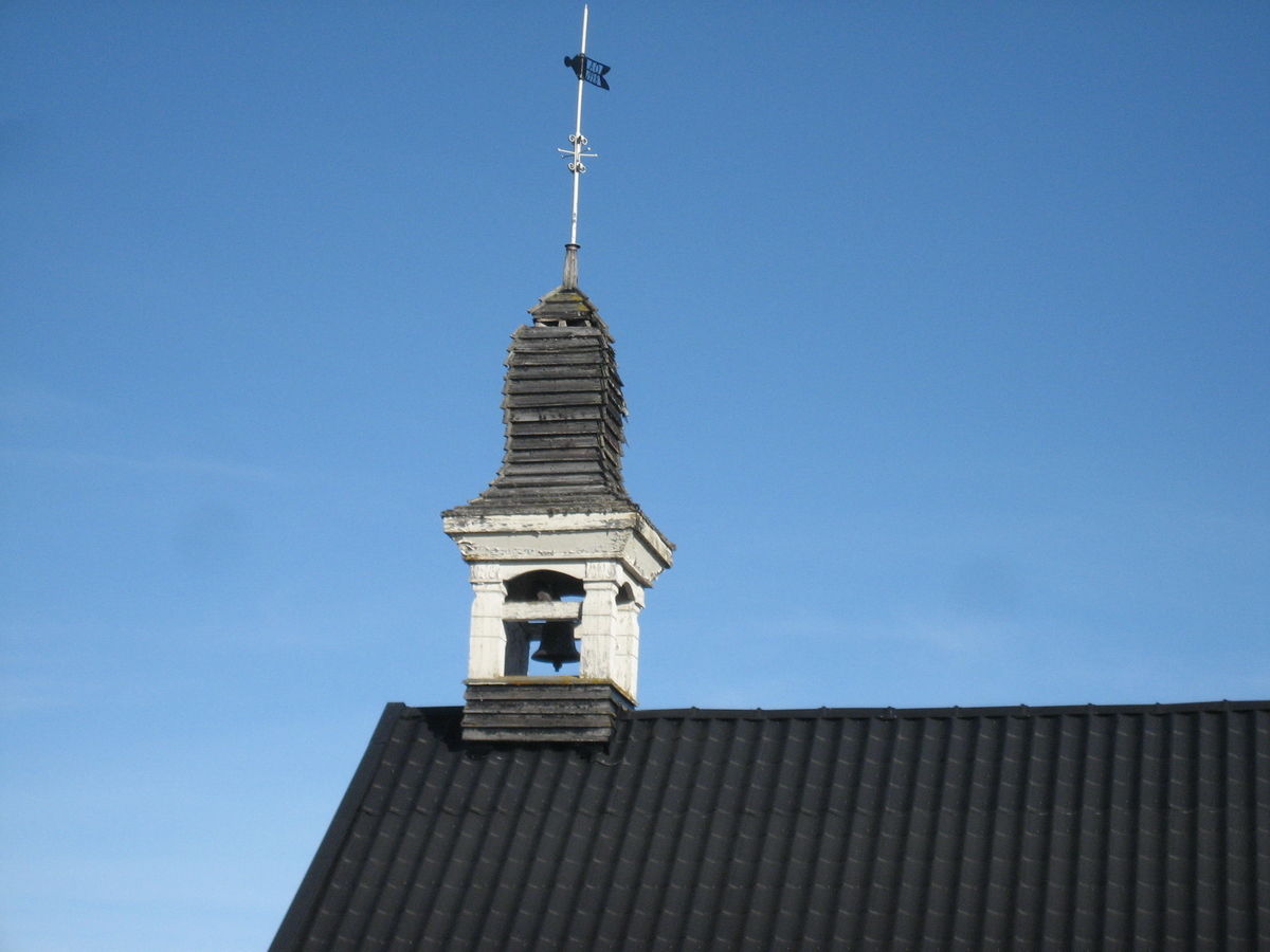 Klokketårnet på Oustad (Austad) har buet teltak. Tårnet er bygget i 1928, og plassert på stabburet.