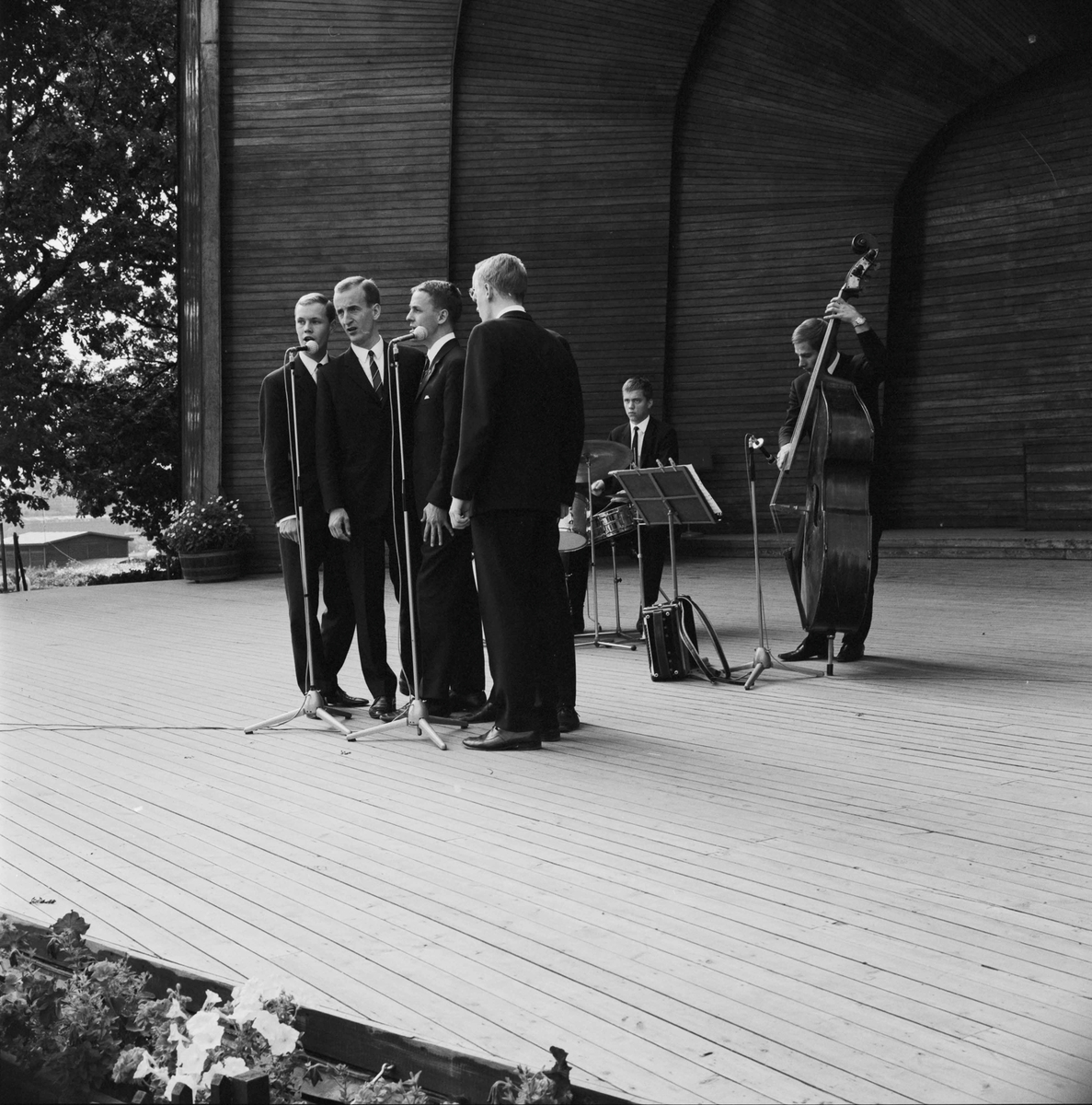 Skansen 75 år. Sollidenscenen, orkester med fem vokalister en man som spelar kontrabas, en trummor.