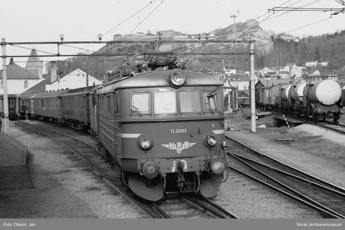 Hensatt persontog på Halden stasjon. Fremst i toget elektrisk lokomotiv type El 11 nr. 2093.