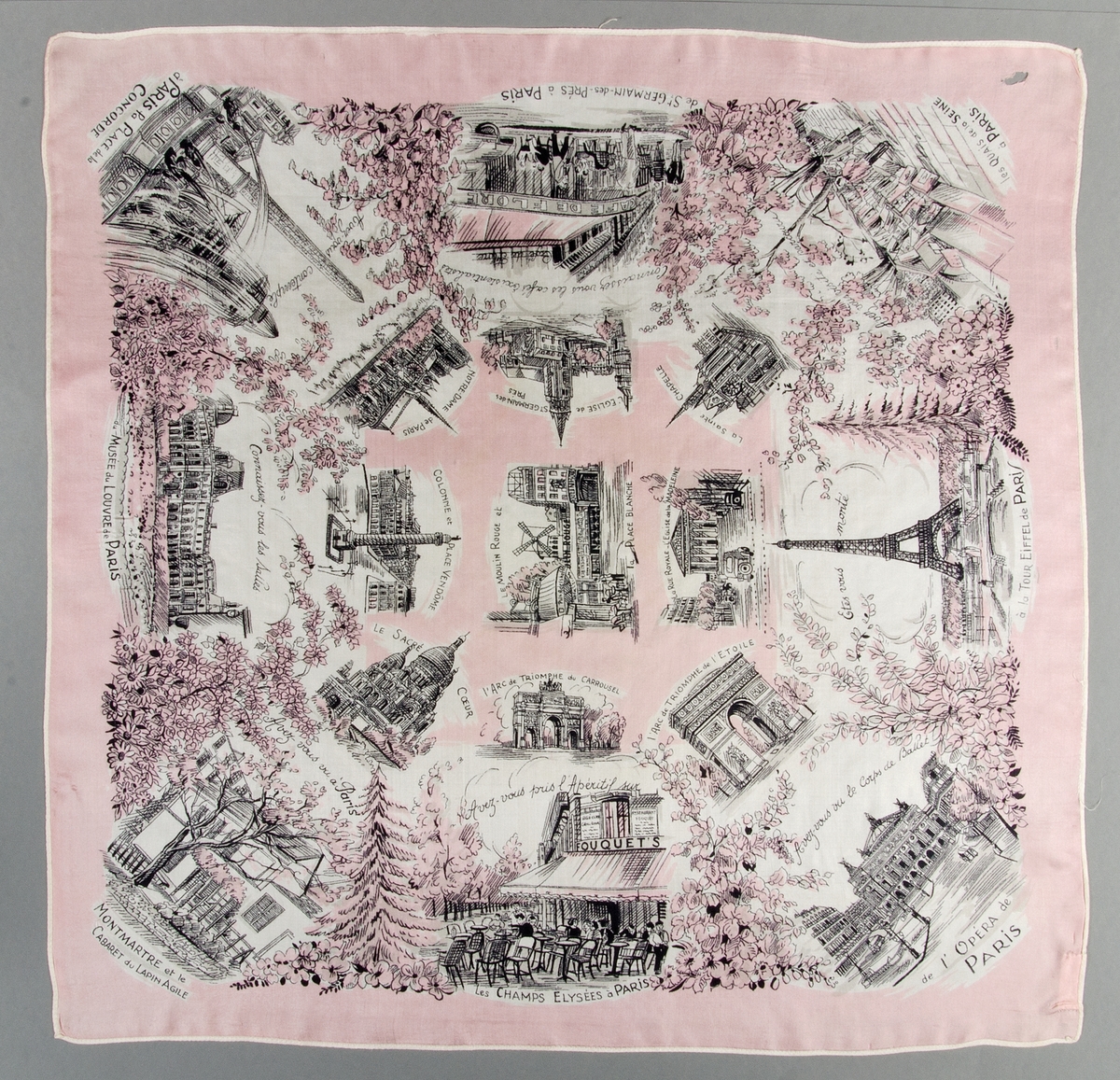 Scarf av siden med svart tryck på vit och rosa botten. Sjutton motiv vilka visar kända byggnader i Paris. Maskinfållad.