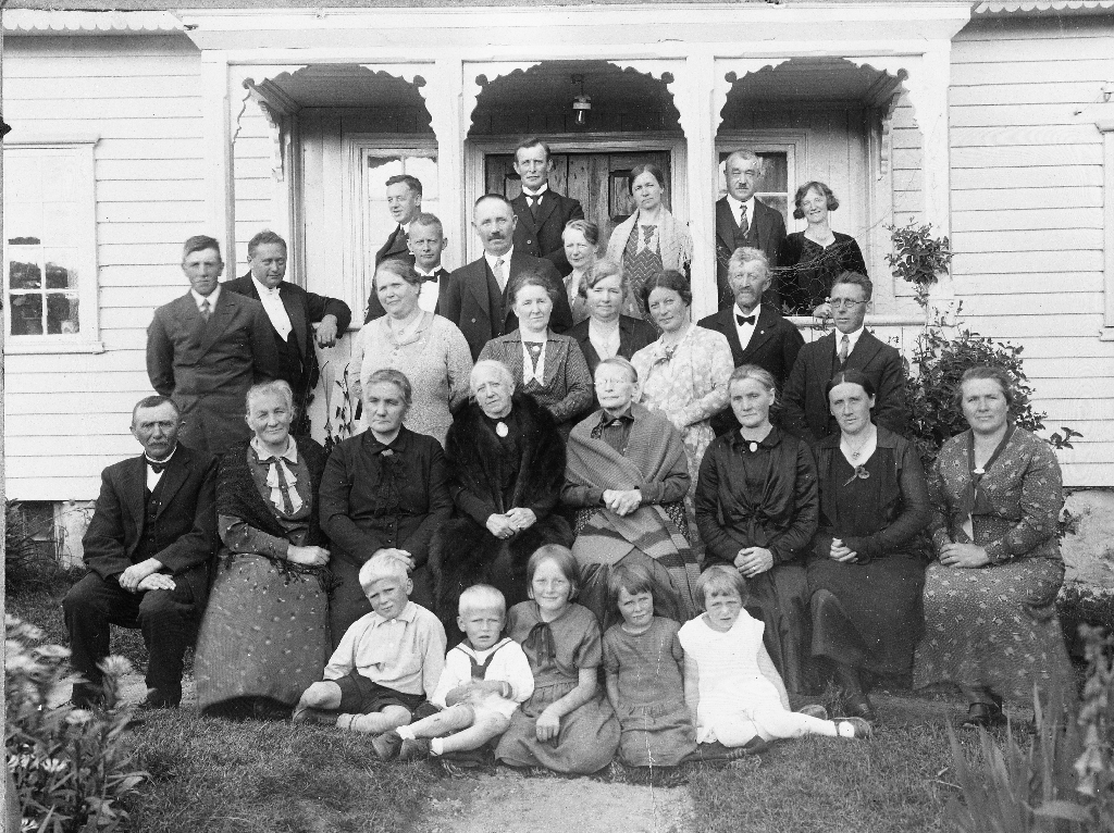 Slektssamling - samling av søskenbarn på Åsland i 1927. Nikolai Steinsland står i andre rekkje f. v. og støtter seg til stolpen. Sitjande lengst til høgre er Taletta Steinsland (1889 - 1968)