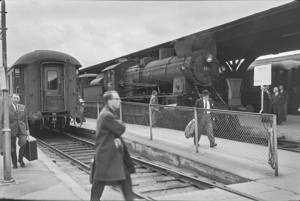 Tog og reisende på Trondheim stasjon. Damplokomotiv type 30b nr. 359.