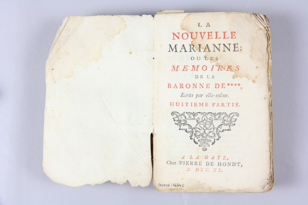 Bok, häftad, "La nouvelle Marianne ou les mémoires de la baronne de ****", del 8, 9,10, tryckt i Haag 1740.
Pärm av marmorerat papper, oskurna snitt. På ryggen klistrade pappersetiketter med volymens namn och samlingsnummer. Ryggen blekt.