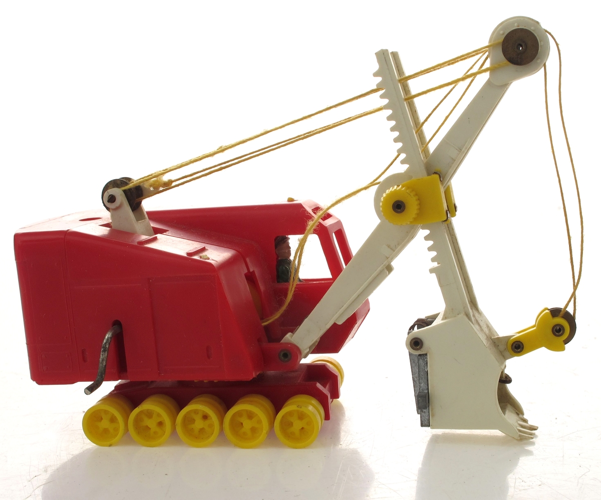 Lekegravemaskin med deler støpt i plast. Mekanisk leketøy ed bevegelige deler, snorer og sveiver, og hjul.