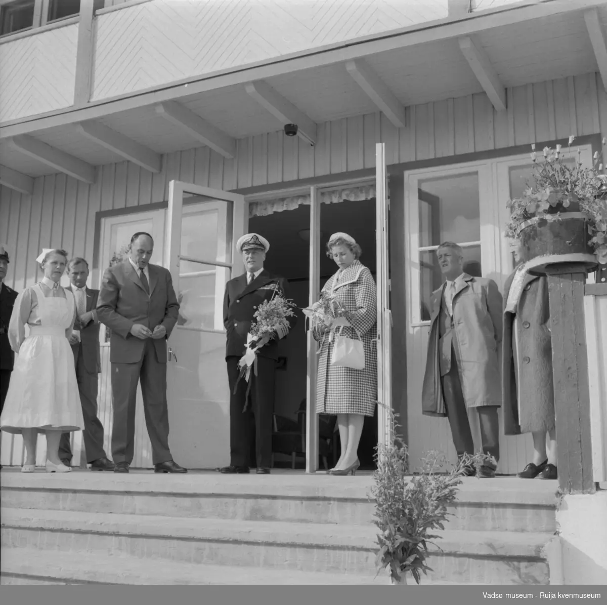 Vestre Jakobselv juli 1959. Kongen på trappa til barnehjemmet Vårsol. Til venstre for Kongen : søster Gunvor og ordfører Henry Karlsen; til høye for Kongen: prinsesse Astrid og fylkesmann Peder Holt.