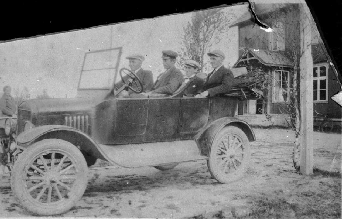 Leirfjord, Ulvangen. Leirfjords første bil, Ford T 1923-24-modell. Den tilhørte Mathis Simsø. Ved rattet: Mathis Simsø, til h. for han Karl Seime. De to personene bak er ukjente.
Bildet er brukt i Leirfjordkalenderen - juni 1986