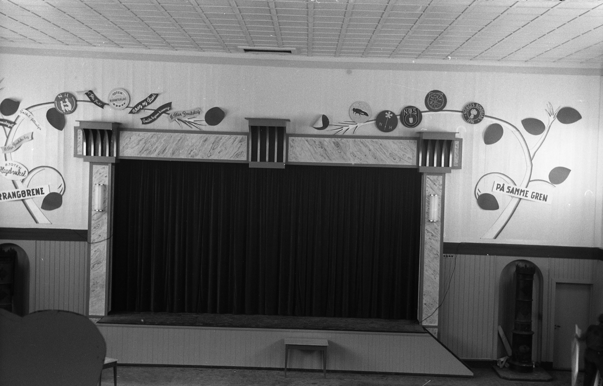 Serie på 29 bilder fra hagebruks- og kostholdsmesse i Østre Toten Festivitetslokale 3-5. november 1953. Motivene er i hovedsak plakater, men også noen interiørbilder fra storsalen i "Teten".