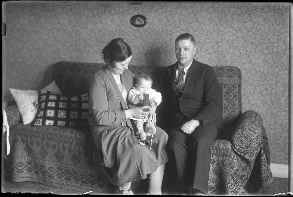 Familjen Pettersson sitter i en soffa. Sonen Lars sitter i knäet på sin mamma Hilda. I fotografens egna anteckningar står det "Sven Petterssons familj".