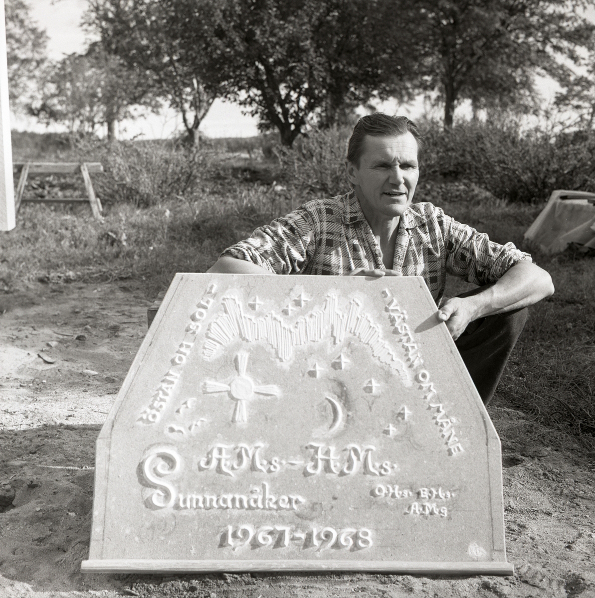 Hilding håller upp en gjutform med årtal och initialer till öppna spisen vid gården Sunnanåker, 1967 - 1968.