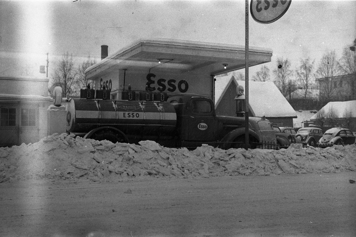 To vinterbilder, februar 1954, fra Esso bensinstasjon på Lena. De tre karene på det første bildet er ikke identifisert.
