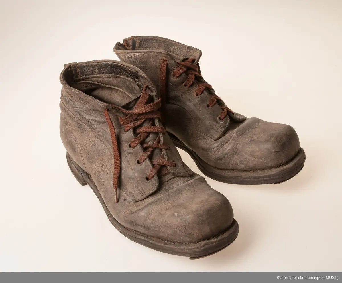 Kraftige støvler med tykk såle, jernbeslått foran, jernstifter under.