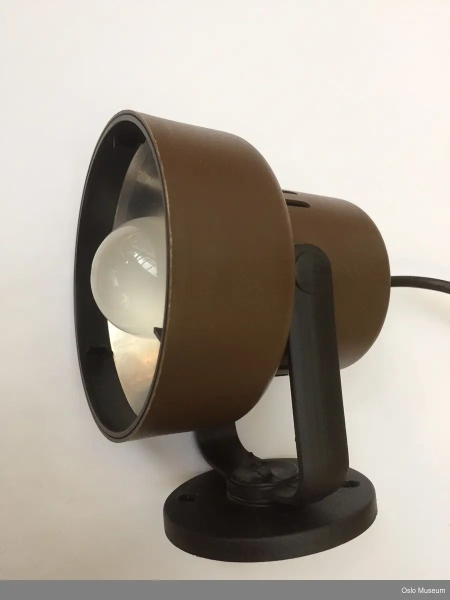 Lampett i brun plast med sort veggfeste og ledning.