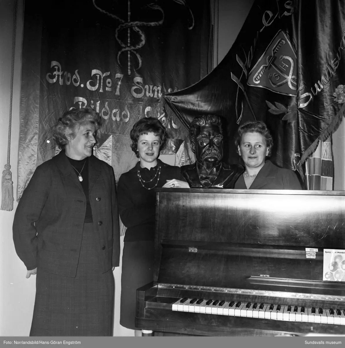 Handels avd 7 har Branting-möte i Folkets hus på hundraårsdagen för Hjalmar Brantings födelse. Tre kvinnor och en byst av Branting vid ett piano.