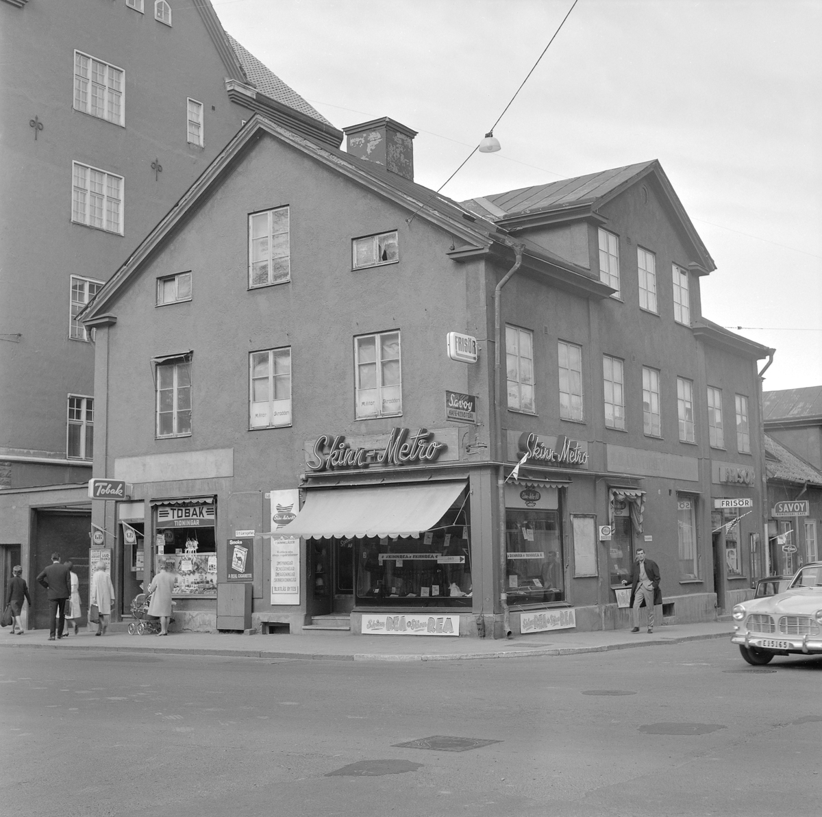 Skinn-Metro rear ut 1965. Huset i hörnet av Sankt Larsgatan och Kungsgatan kommer att rivas inom kort. När byggnaden uppfördes under 1850-talets senare hälft var den en av flera liknande hus som praktfullt bildade Linköpings norra gräns. Vid tiden för bilden låg det varken i stadens utkant eller bedömdes vara särskilt imponerande.