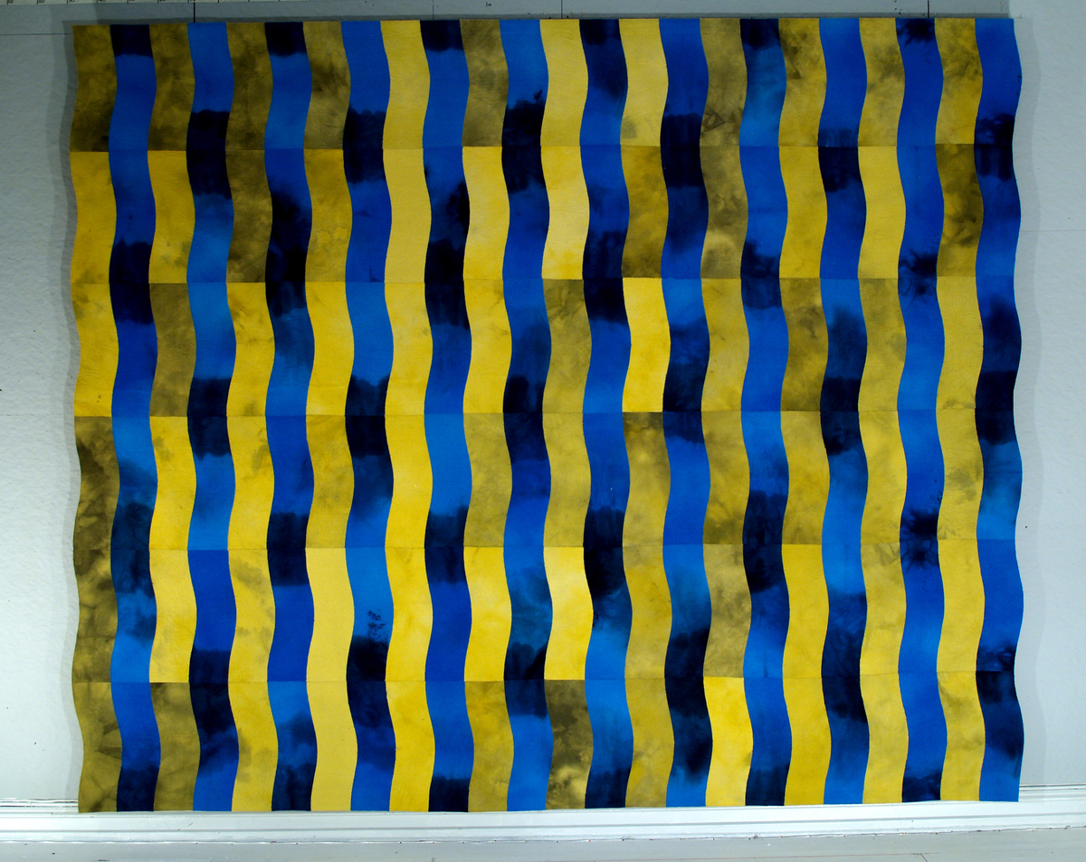 Tekstil med gule og blåe render som bølger seg nedover.