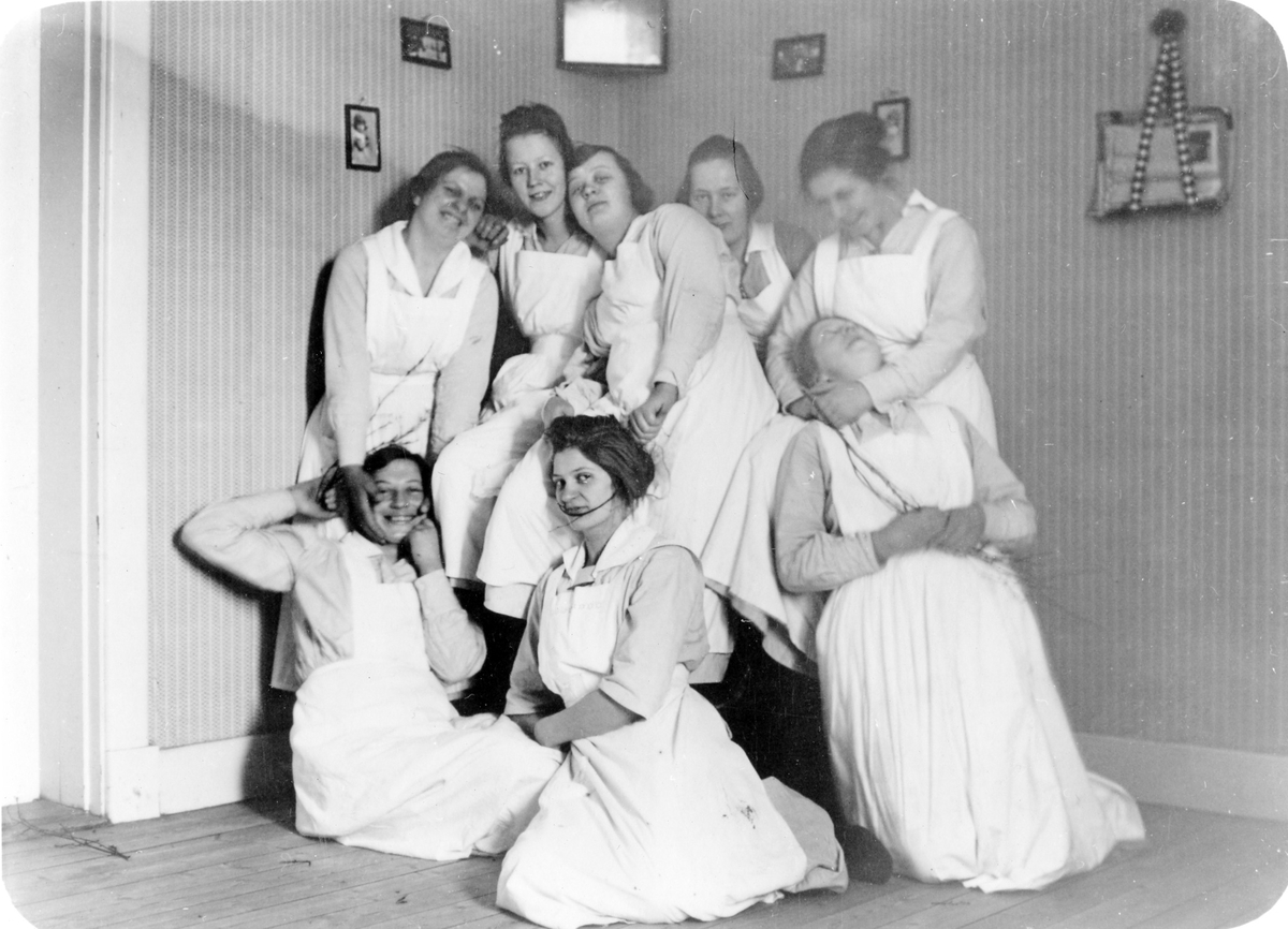 Gruppbild av 8 kvinnliga (troligen) biträden som spexar inför kameran.