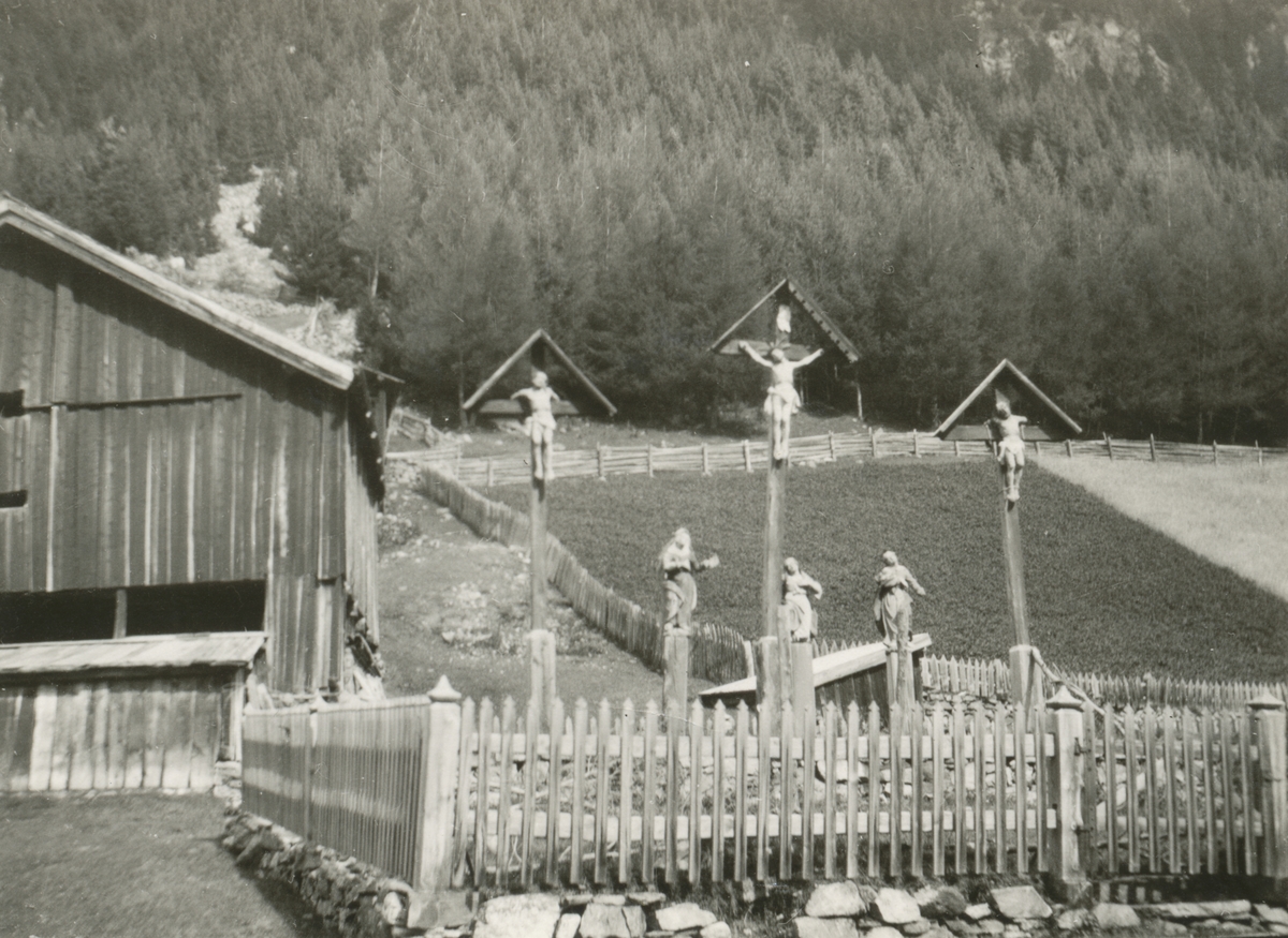 Motiv av noen trefigurer som skal fremstille Jesu korsfestelse ved landeveien i Syd- Tirol.
