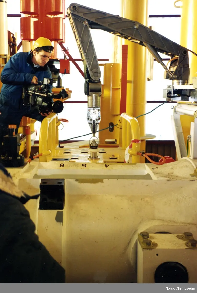 Filmfotograf dokumenterer en ROV-arm under koblingsarbeid.  Dette er en del av produksjonen av brønnrammer til Nornefeltet.