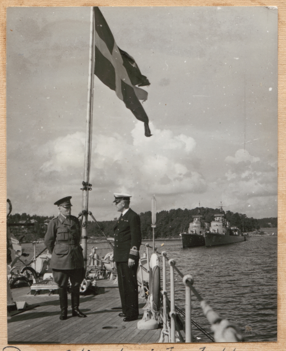 Den f.d. överbefälhavaren general Thörnell hälsas välkommen ombord på Fylgia. I bakgrunden syns jagarna Norrköping och Stockholm till ankars.