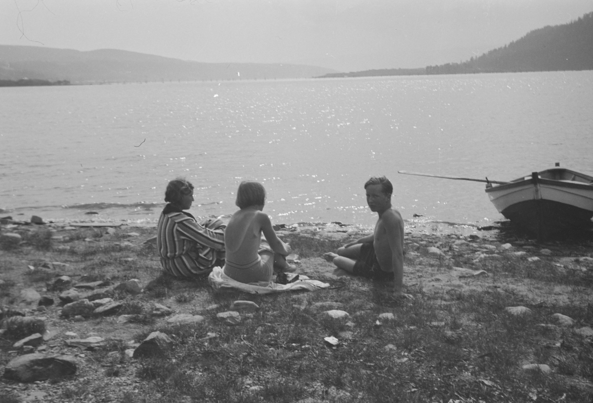 Ungdommer på strand med robåt.
