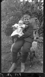 Portrett av gutt med barn på armen.