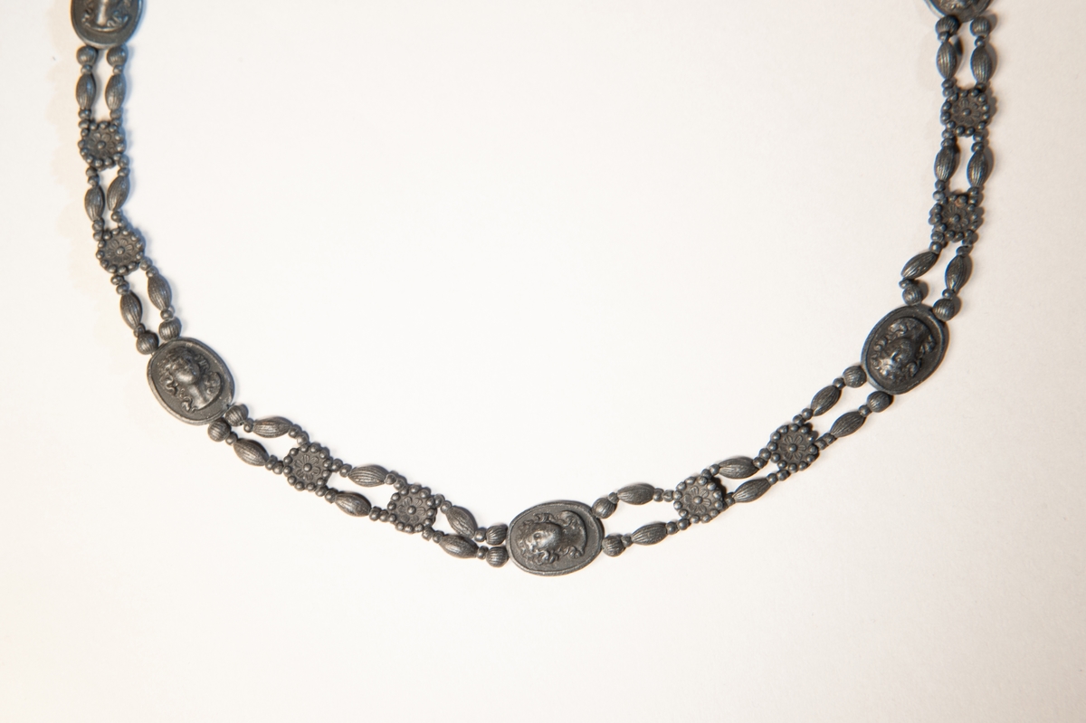 Halsband, bestående av dubbla rader "pärlor" av svart lavasten (?) med ovaler med antika motiv emellan.