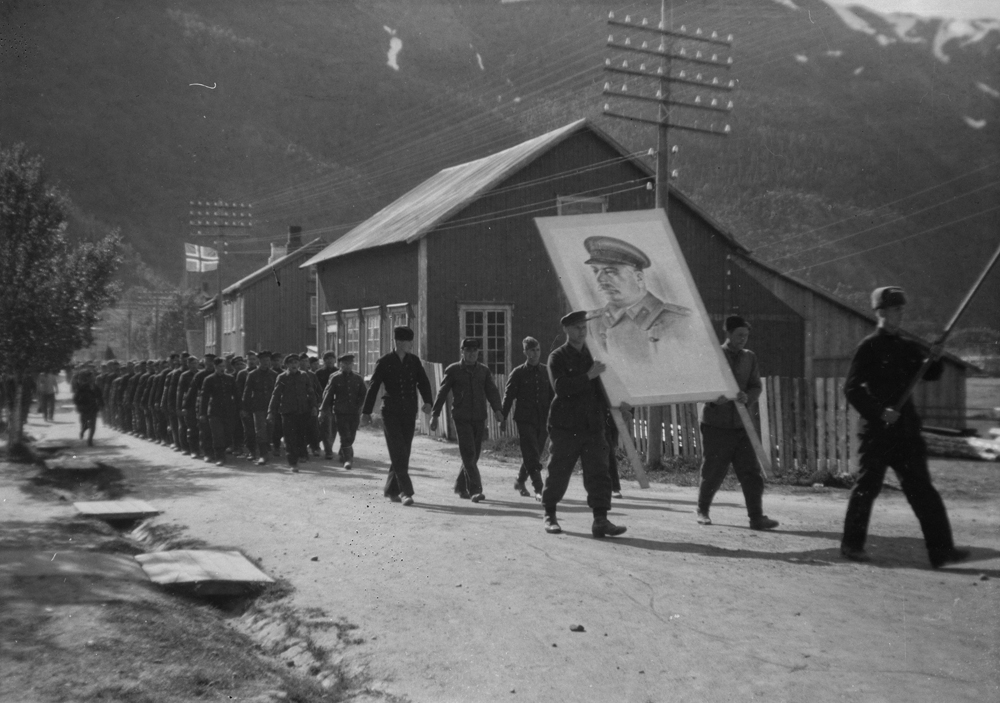 Krigsfanger marsjerer i Skjervgata ved "Abelbakken", bærer stort bilde av Stalin.