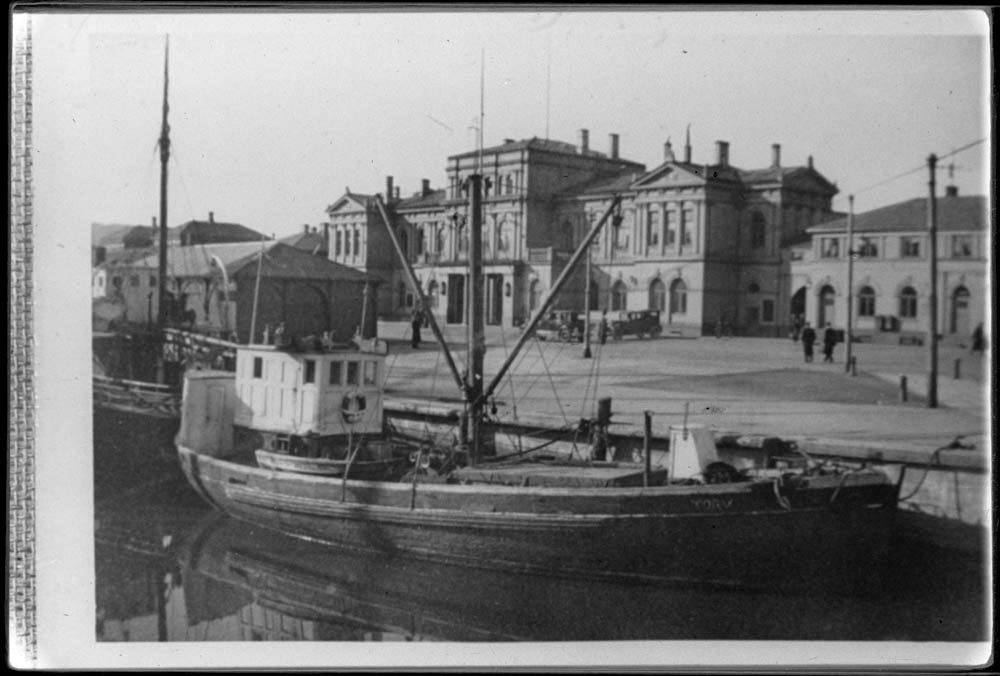 Trondheim jernbanestasjon med Fosenkaia og frakte-/fiskefartøy i forgrunnen. Bilen tyder på 1920-tidlig 30-tall.