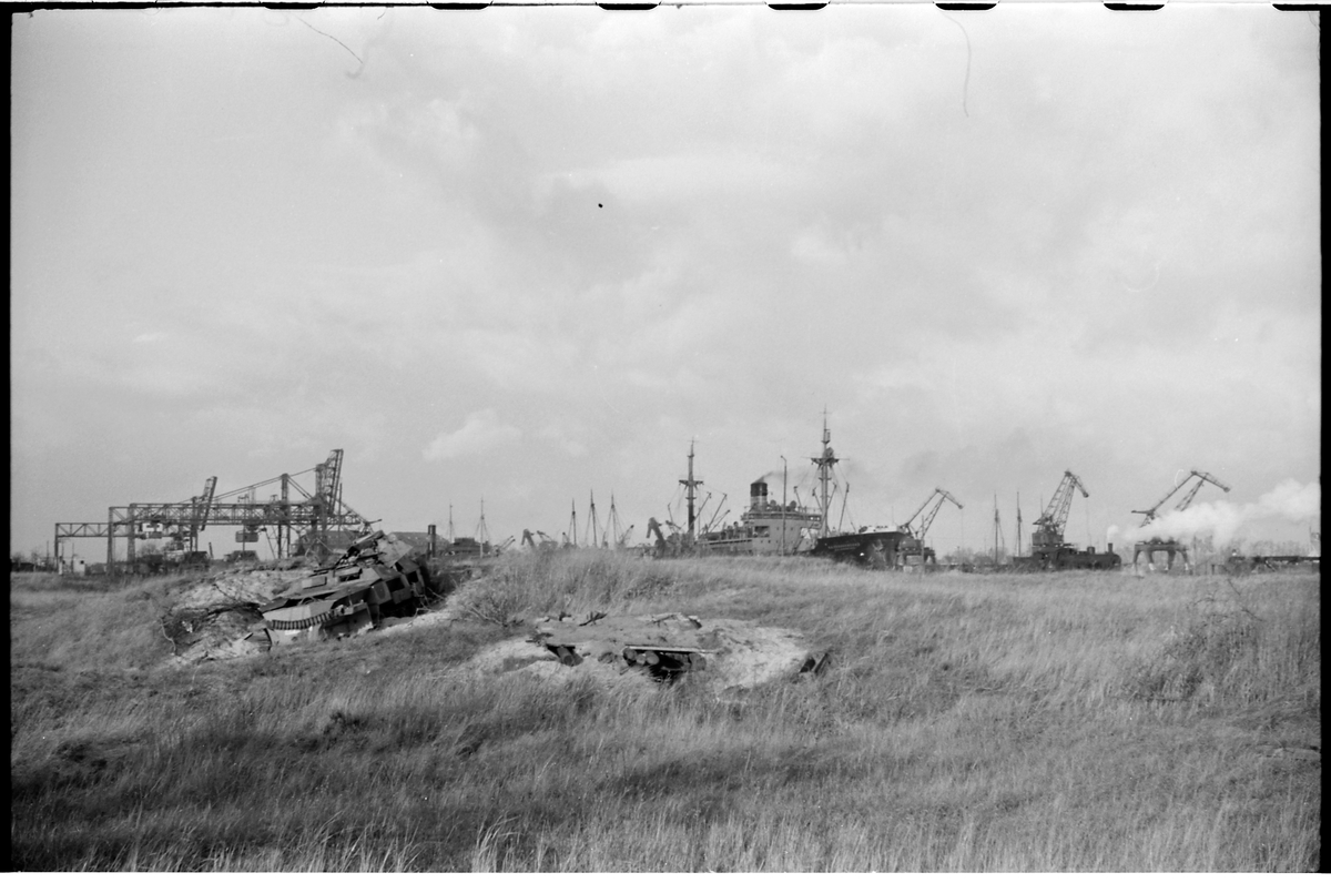Fartyg vid hamn i Gdansk. I förgrunden syns resterna av en förstörd pansarvagn.