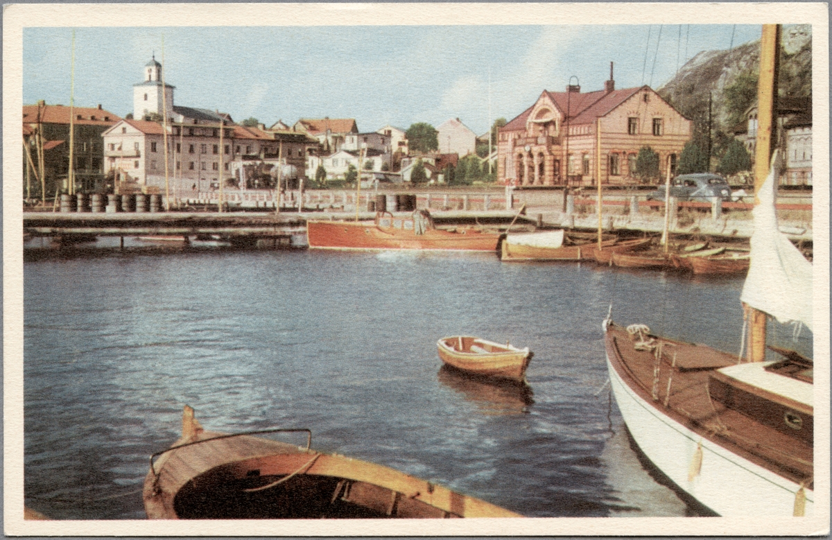 Järnvägsstationen och kyrkan i Strömstad fotograferat från båt eller brygga.