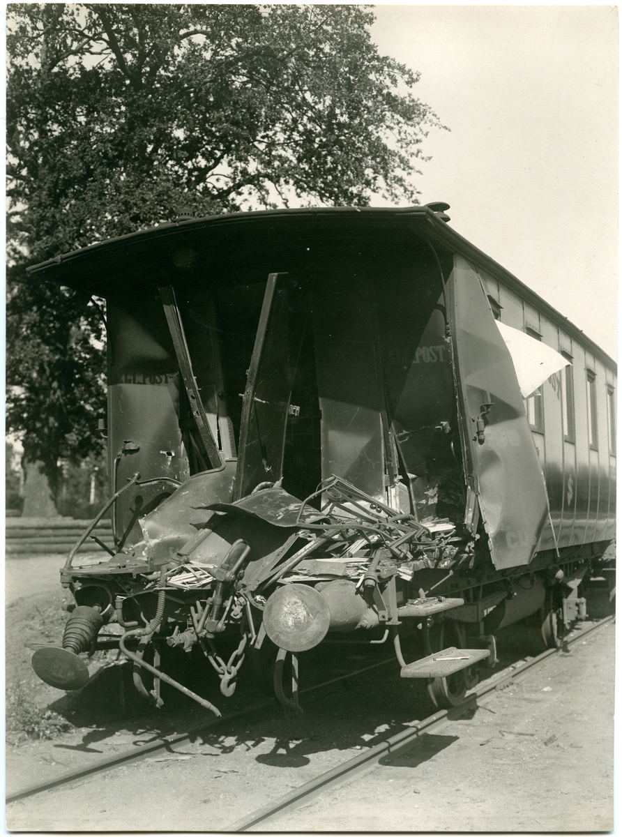 Krockad postvagn med skador. På bilden står Sammanstötningen i Motala 1925.