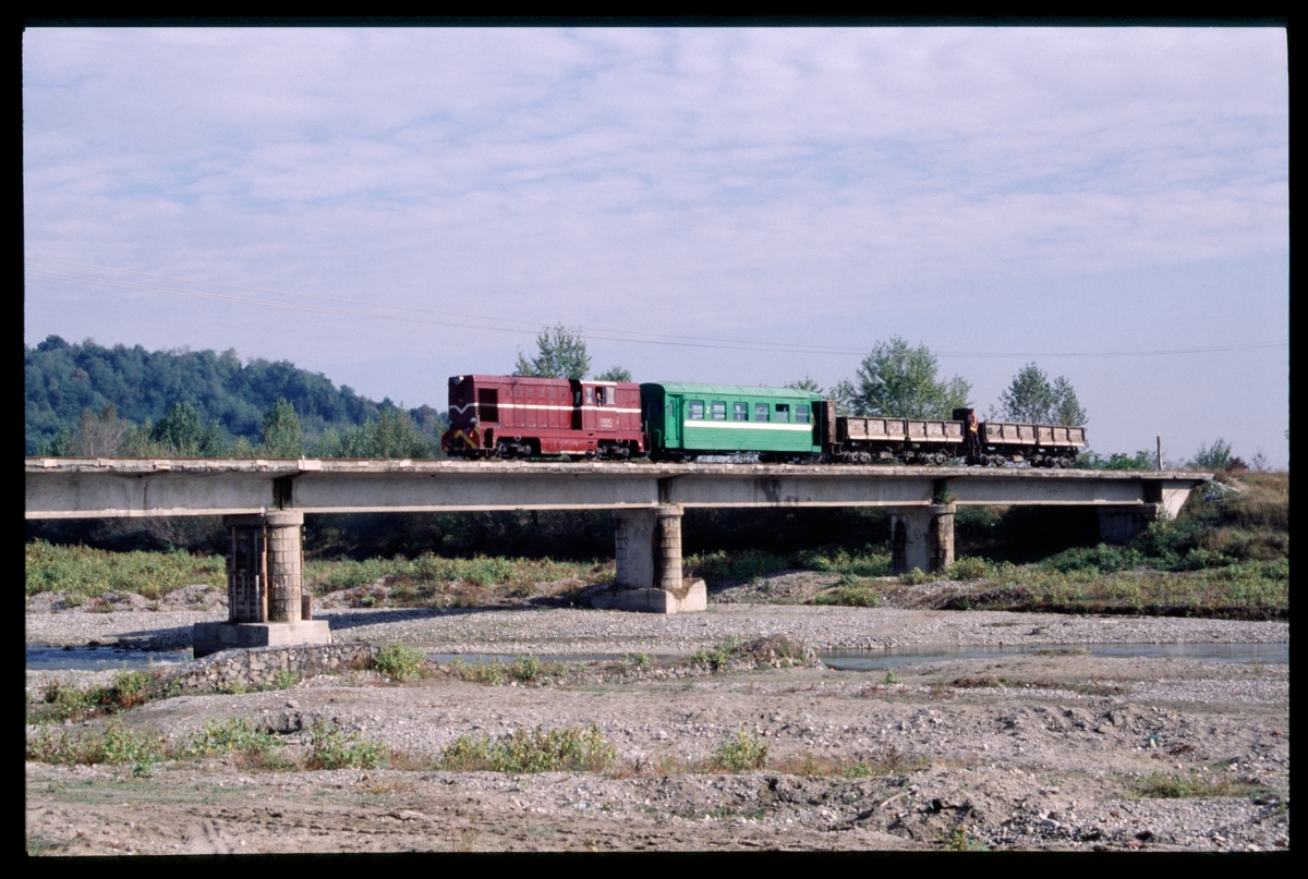 DIeselloksdrivet tåg på järnvägsbro på sträckan mellan Govora och Bistrița, Rumänien.