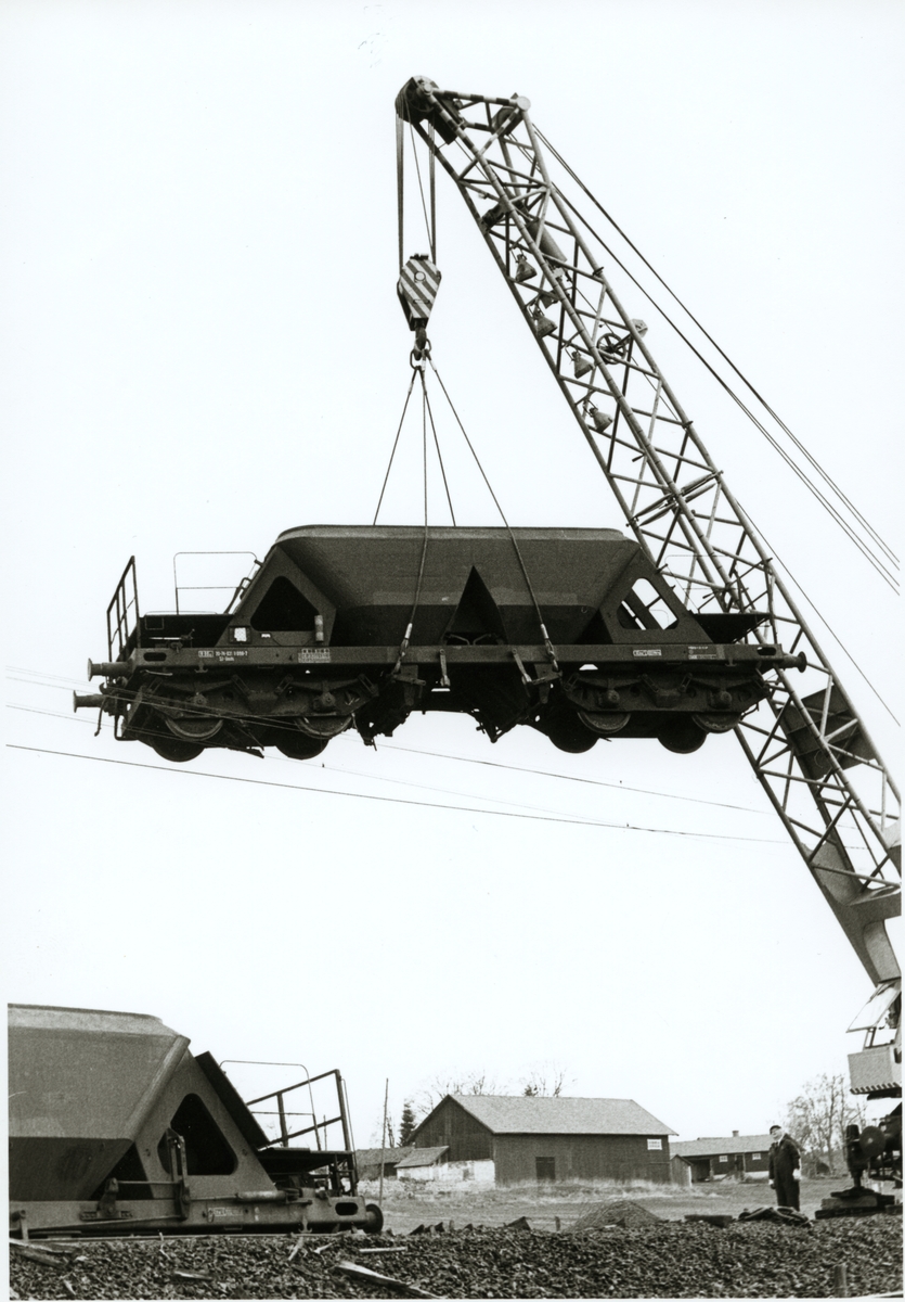 En kranvagn tillverkad av Schwermaschinenbau SM Kirow med littera Statens Järnvägar, SJ Qan lyfter en urspårad malmvagn.