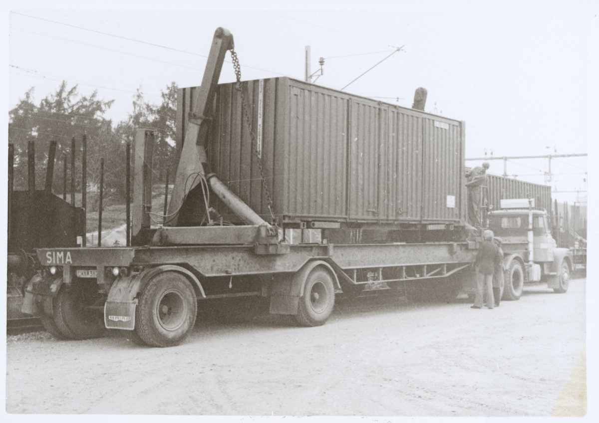 Lastbil utrustad med simalift för sidolyftning av container.