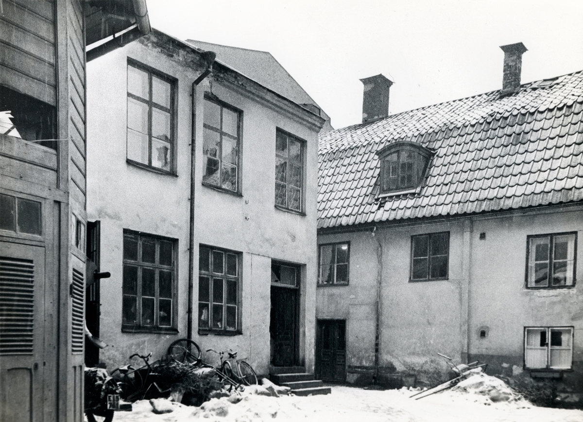 Gårdsinteriör från Ertman Wulfs gård inom kvarteret Haken, beläget vid korsningen av Tunnbindaregatan och Vattengatan i Norrköping. Bilden är tagen i samband med rivningsansökan 1956. Vy mot nordost.
Byggnaden är ett av två hus som räddades vid den 'norra branden' som utbröt i kvarteret 1826. Båda husen hade upplysningsvis vackra väggmålningar från 1700-talet vilka idag ingår i Norrköpings stadsmuseums samlingar.