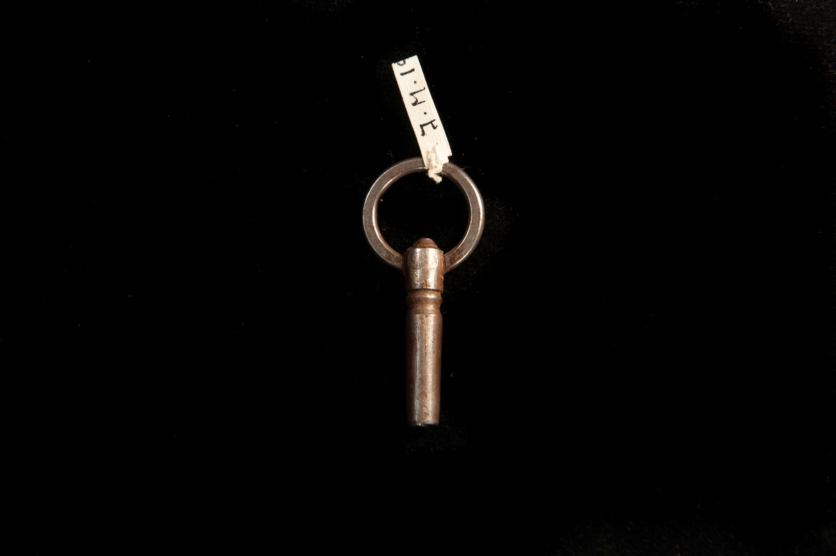 En urnyckel av järn med handtag i form av en cirkel. Något grövre nyckel.
