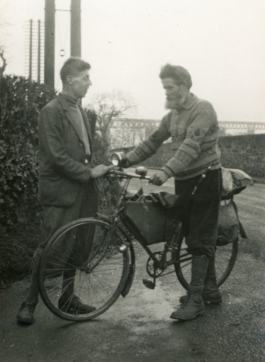 Ingvald Skjeldrup står ved sin sykkel sammen med en annen mann ved Forth Bridge, Skottland.